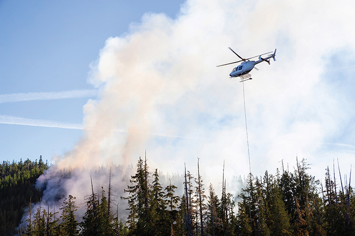 Helicopter fighting forest fires. Taken near Port Alice, Northern Vancouver Island, BC, Canada