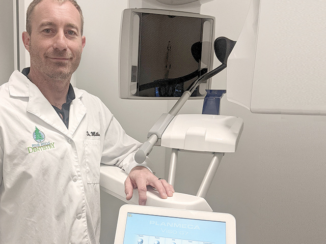 Dentist showing a piece of his state-of-the-art equipment