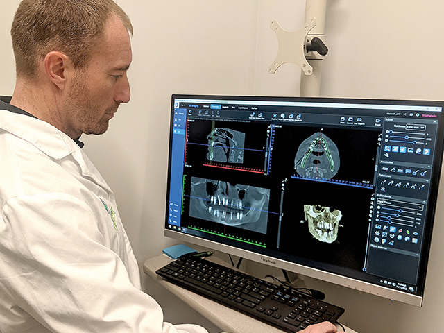 Joseph Miller, DDS, implantologist, at computer screen