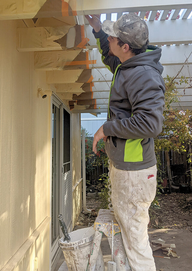 Painter using non-VOC paint on a house